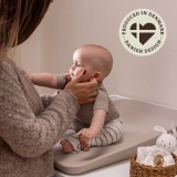 Mama przewijająca dziecko na macie w kolorze cappuccino