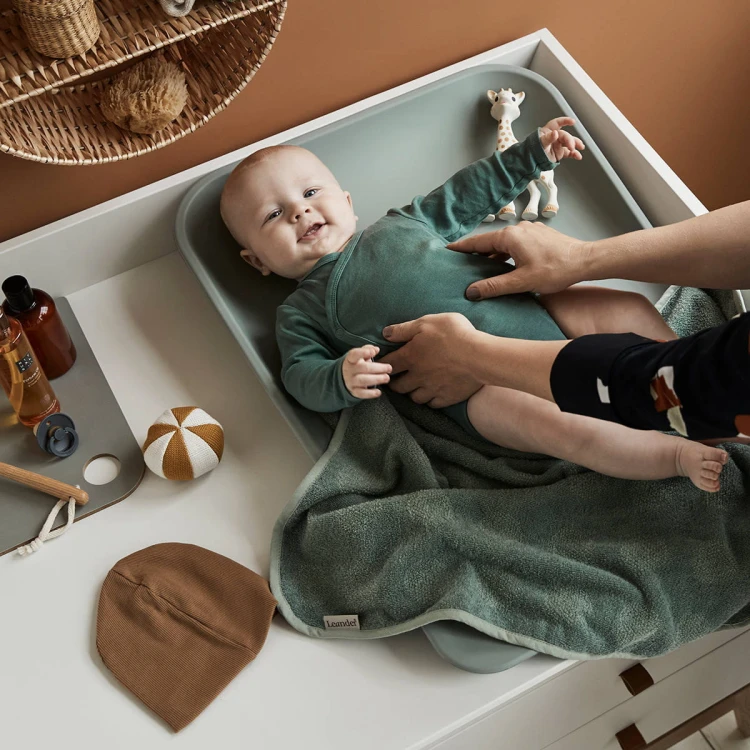 Dziecko bawiące się na macie do przewijania sage green