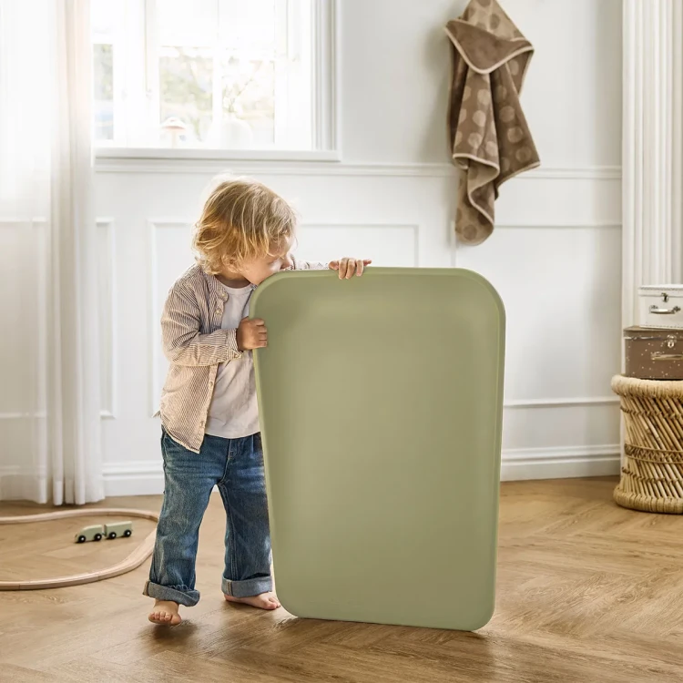 Dziecko przy macie olive green opartej o komodę