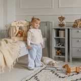 Dziewczynka w pokoju dziecięcym urządzonym jasnoszarymi meblami Collet
